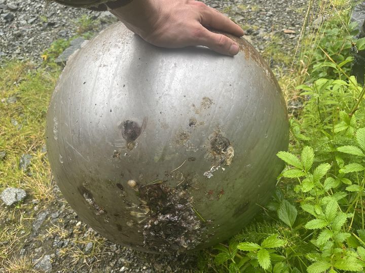 A metal sphere, about 16 inches wide, was found floating. It’s hollow with a weighted base attached by six welds, yet it floats high in the water.